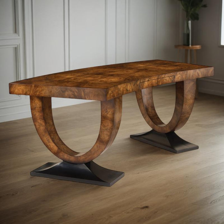 The Curved Walnut Desk by John Richard, pictured in a room with paneled walls