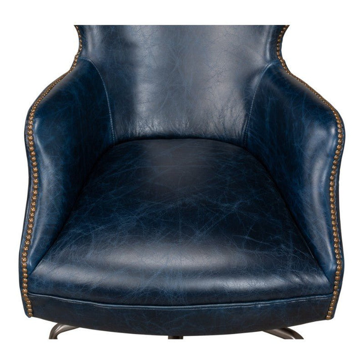 Image of the sophisticated Andrew Jackson Desk Chair in Chateau Blue by Sarreid, featuring bronze nailhead trim along the edges. This chair showcases a padded seat, high backrest, and curved armrests crafted from pure aniline top-grade cowhide leather, combining luxurious comfort with exquisite design.