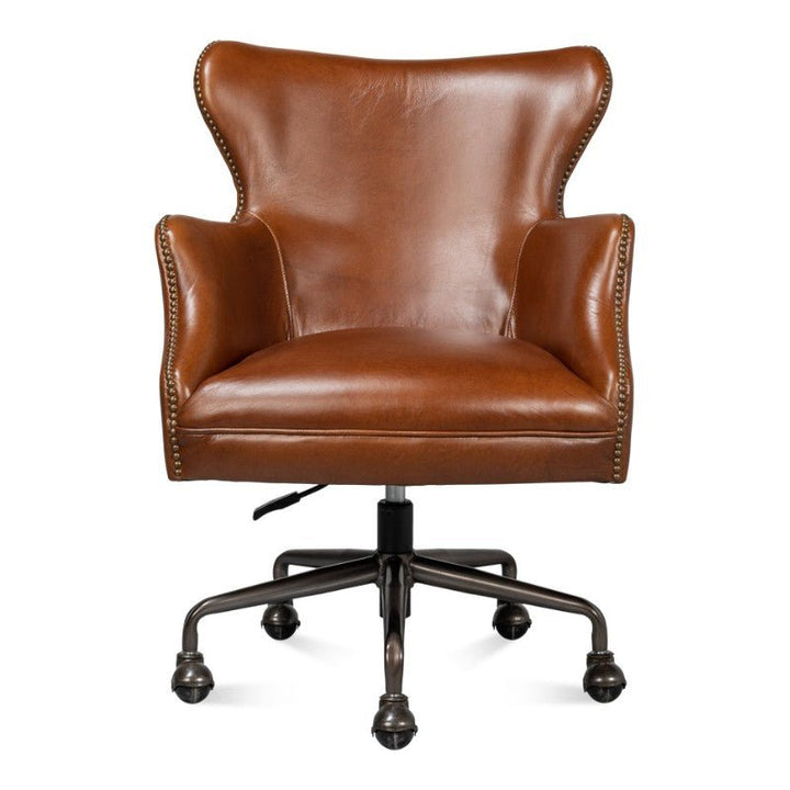 The Andrew Jackson Desk Chair in Havana Leather by Sarreid is a high-back office chair featuring Vintage Havana leather and brass nailhead trim. It includes armrests, a swivel base with five caster wheels, and an adjustable height lever. The rich chestnut brown color adds a sophisticated, transitional touch to any workspace.