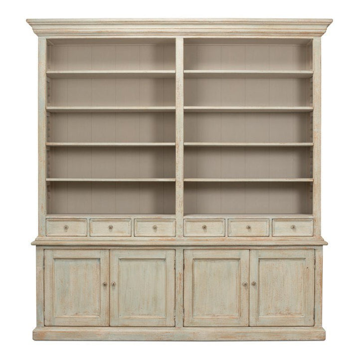 The Angelique Bookcase by Sarreid is a large cabinet with a rustic finish, crafted from reclaimed pine. It features two sections of shelving at the top, each with five shelves, and a total of eight small drawers beneath. Below the drawers are four cupboard doors with handles. This bookcase exudes a worn, antique appearance that adds coastal charm to any space.