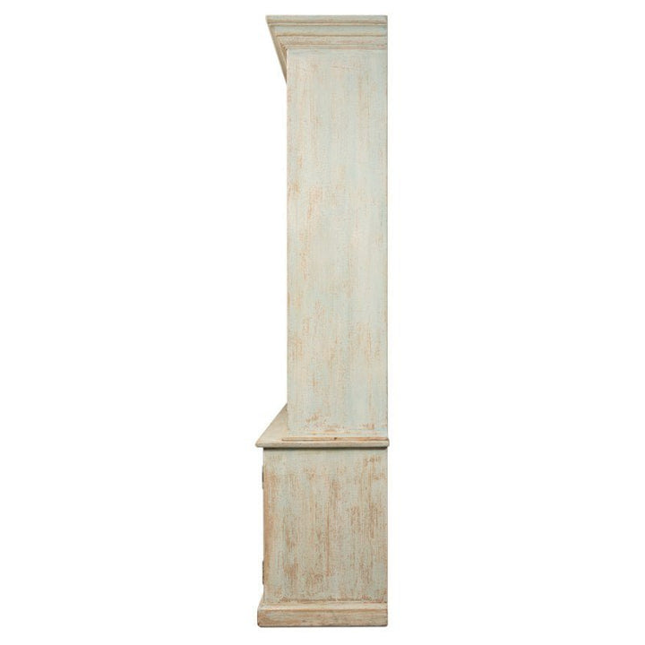 Side profile of the Angelique Bookcase by Sarreid, a tall, distressed wooden cabinet with a weathered, antique blue wash finish. The cabinet features a classic design with a crown molding top and a rectangular base, exuding coastal charm and vintage rustic appeal. No doors or shelves are visible.