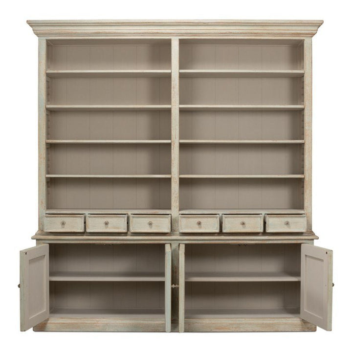 The Angelique Bookcase by Sarreid is a spacious wooden bookshelf adorned with a distressed white finish that exudes coastal charm. It offers two main sections filled with multiple shelves and includes a central row of small drawers. Additionally, four cabinet doors provide extra storage space at the bottom, two of which are open to reveal interiors crafted from reclaimed pine.