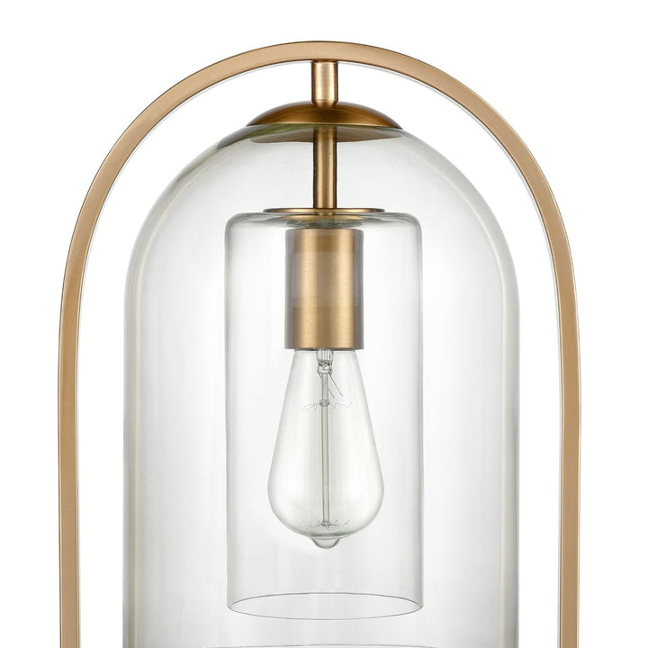 The Bell Jar 28" High 1-Light Desk Lamp from Elk Home showcases a teardrop-shaped, vintage-style bulb encased in a clear glass dome with an aged brass frame. Its sleek and minimalist design makes it perfect for modern farmhouse settings, emphasizing its industrial aesthetic.