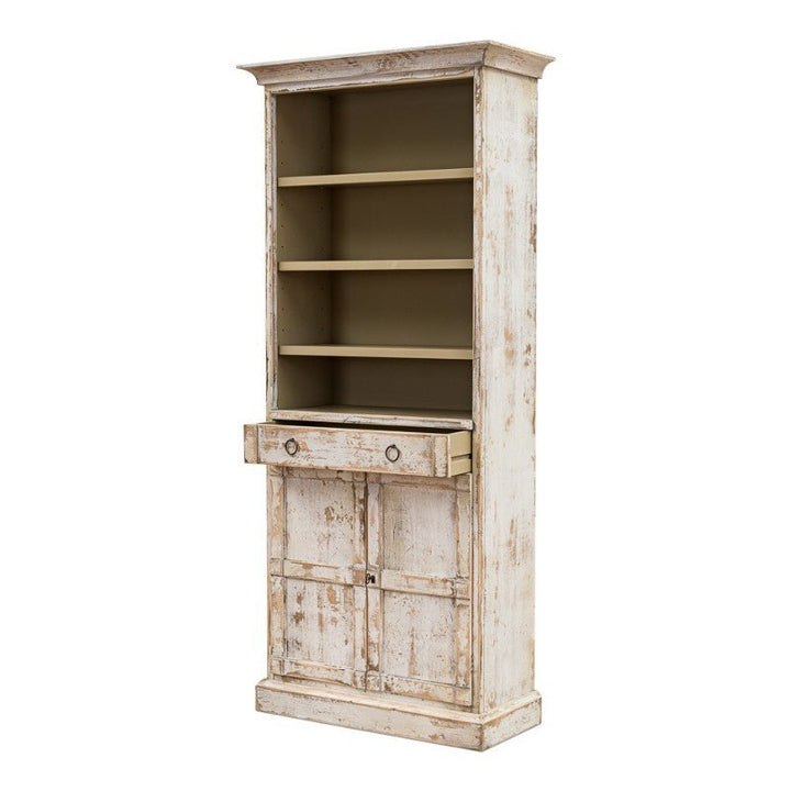 The Sarreid Bookcase With Doors in a disrupted white finish is an elegant, vintage piece. It features a tall wooden structure with four open shelves in the upper section, and the lower section includes a central drawer and two paneled doors for extra storage.