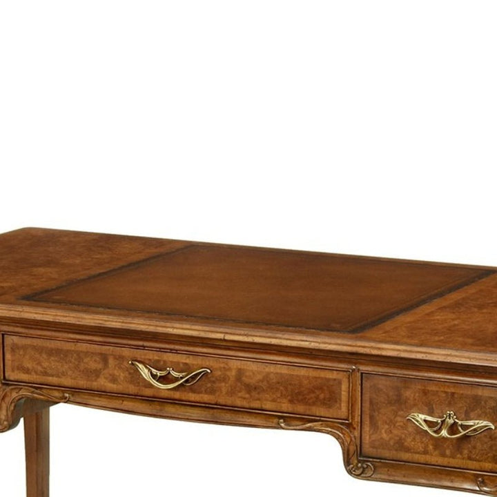 The Burl Walnut Lady's Writing Desk by Aston Court showcases a polished surface with intricate carvings and two front drawers adorned with ornate brass handles. This vintage design emphasizes classic decorative details on the legs and edges, making it an elegant addition to any sophisticated space.