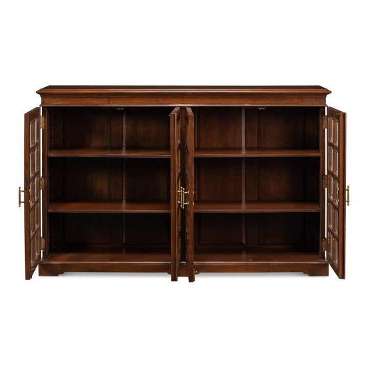 A Carmel-By-The-Sea Bookcase, Walnut by Sarreid, is displayed with its four doors open, revealing six shelves inside. Each door features glass panels and antique brass accents. This solid walnut cabinet boasts a classic and elegant design.