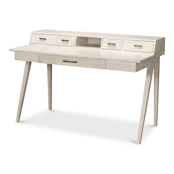 The Covet Desk - Sarreid by Sarreid is a modern piece in an Ivory Bianca finish. This minimalist light wood desk features angled legs, two small drawers on each side, a central open compartment, and one large drawer beneath the writing surface, providing practical functionality with its clean and simple design.