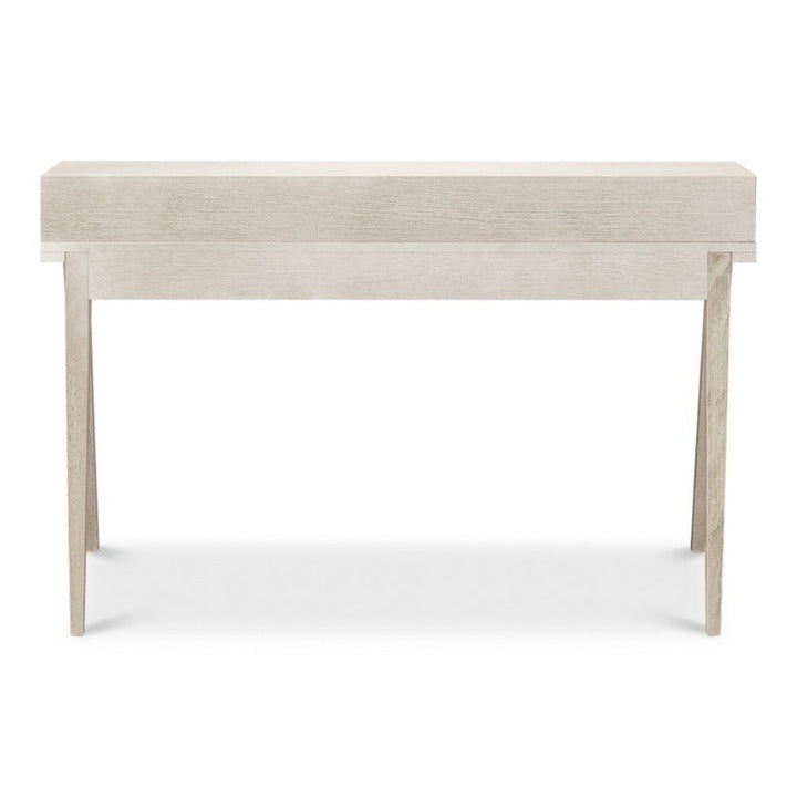 The Sarreid Covet Desk is a minimalist, light beige-colored wooden console table featuring an Ivory Bianca finish. With clean lines, it boasts a flat rectangular top supported by four slightly outward-angled straight legs. Its simple and modern design provides practical functionality, making it perfect for contemporary interiors.