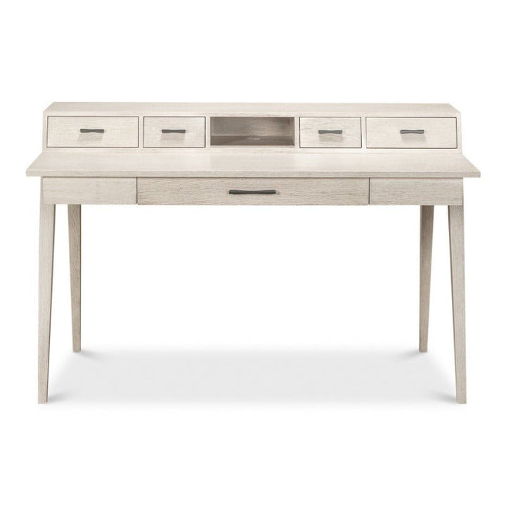 The Covet Desk by Sarreid is a modern piece with practical functionality, featuring a light, weathered Ivory Bianca finish. It includes four small drawers aligned along the top and one wide drawer centered below the tabletop. The desk stands on four tapered legs and has an additional open compartment in the upper middle.