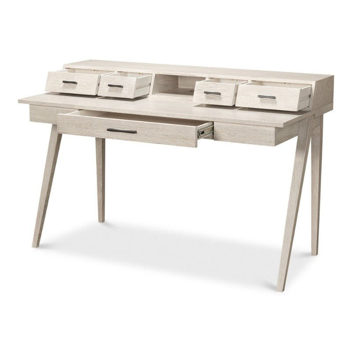 The Covet Desk - Sarreid by Sarreid is a modern piece featuring an Ivory Bianca finish. It boasts angled legs, a central slide-out drawer, and four small storage compartments on the top. This desk showcases a minimalist design with clean lines, providing practical functionality for a contemporary workspace.