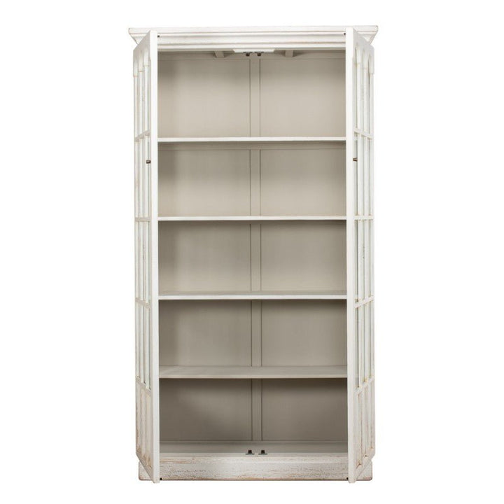 The Edgar Allan Glass Bookcase by Sarreid is a rustic, white-painted, tall wooden bookcase crafted from reclaimed pine. It features four open shelves and a glass-fronted door. With its distressed whitewash finish, this piece boasts a vintage look and traditional design. It stands on a solid rectangular base with a peaked top.