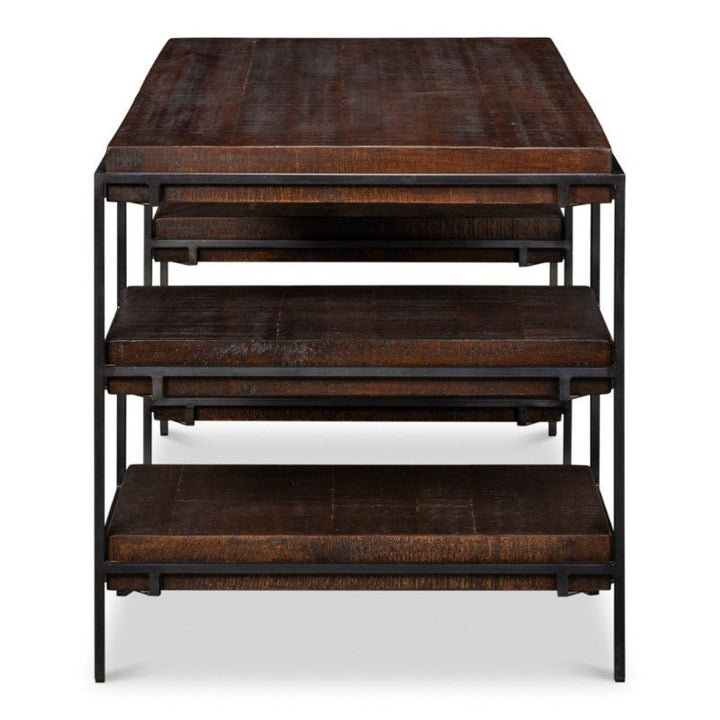 Introducing the Sarreid Ernest Desk, a stunning piece featuring a 60-inch top made from dark-stained mango wood paired with an iron frame. This modern, minimalist design evokes an industrial aesthetic while offering practical functionality. The desk allows for neat stacking of two smaller tables beneath the largest one.