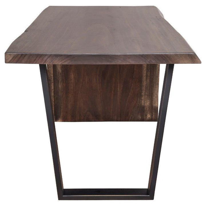 The Heritage Guanacaste Live Edge Waterfall Desk 54" by Fairfield Chair features a wooden tabletop with a rectangular live-edge showcasing the natural wood grain. The desk is supported by a sleek, black metal trapezoid base, with a central wooden panel positioned vertically between the two legs.