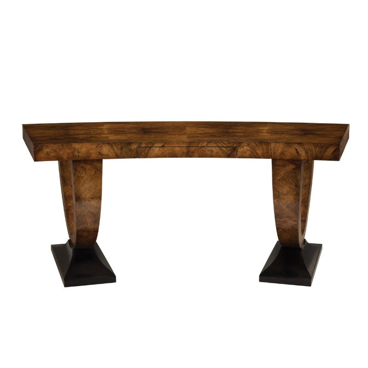 A wooden console table with a curved edge and a rich brown finish, reminiscent of the John Richard Cerejeira Desk 77", features two arched legs, each ending in a flat black base. The distinctive wood grain pattern adds a stylish touch, making it an elegant and sophisticated refined centerpiece by John Richard.