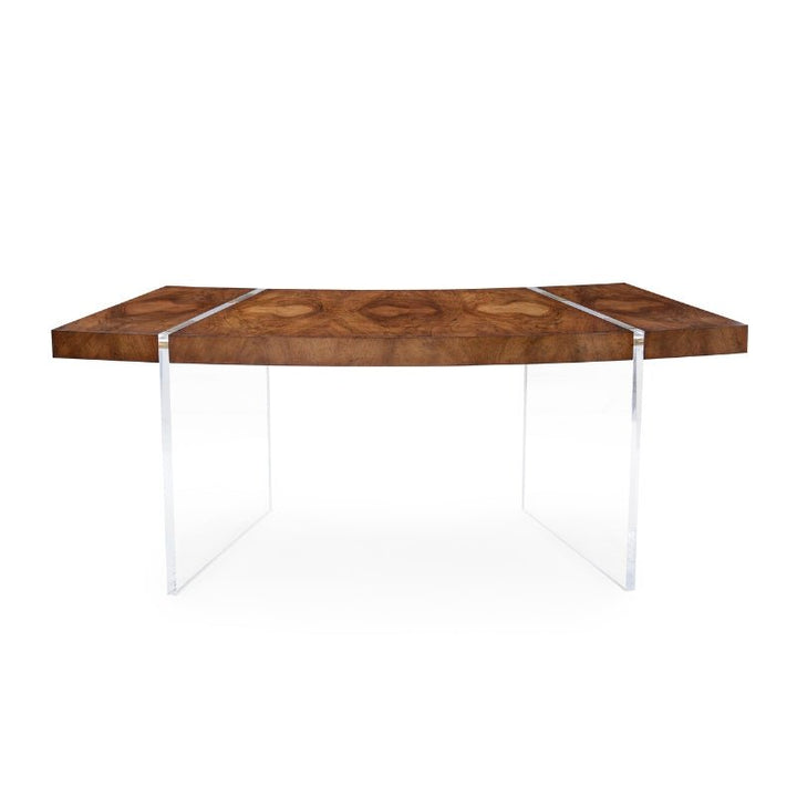 The John Richard Deco Desk is a modern wooden dining table with a rectangular top featuring a geometric cerejeira veneer wood grain pattern. It is supported by two clear acrylic legs, giving it a sleek and minimalist appearance. This versatile piece is stylish enough to serve as both a dining table and a home office desk against the plain white background.