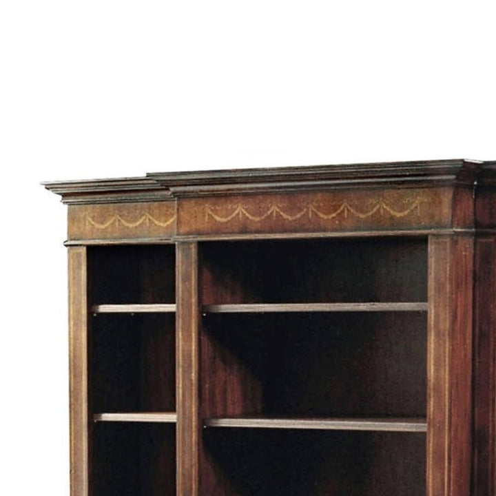 The Aston Court Large Mahogany Bookcase showcases empty shelves and an elaborately carved top edge. Known for its luxurious craftsmanship, this bookcase boasts a dark brown finish with detailed carvings along the top panel, set against a plain white background.