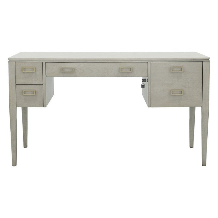 The Libby Langdon Patton Desk 54" by Fairfield Chair showcases a sheer dove gray finish and a light gray, rectangular wooden design. It includes four drawers on the left side, one centered drawer, one large drawer on the right, and brass hardware. The desk features tapered legs and exhibits a minimalist aesthetic.