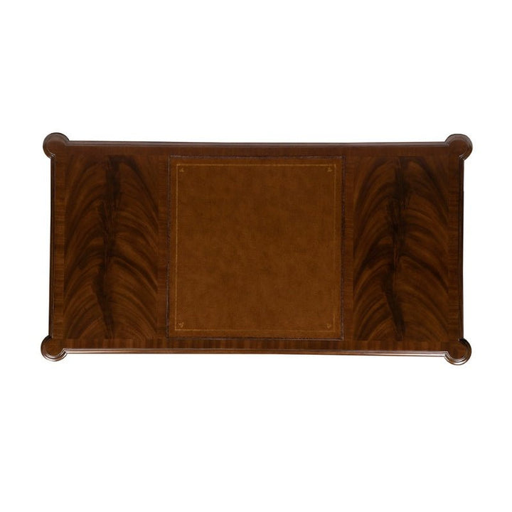 The Mahogany Lady's Desk by Aston Court is a rectangular wooden piece with a polished surface, featuring a central lighter brown section surrounded by a darker wood grain pattern that evokes the beauty of crotch mahogany. The desk's rounded corners add an elegant touch to this exquisite piece.