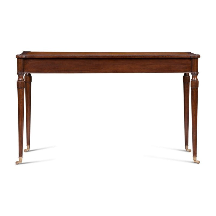 The Mahogany Leather Top Writing Desk by Aston Court features a polished finish, a rectangular leather top, and four tapered, fluted legs with brass caps on the feet. This timeless design is simple yet elegant, making it suitable for various settings such as a living room, dining room, or hallway.