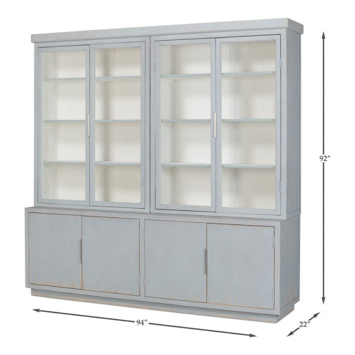 The Maldives 4 Door Bookcase, Eros Blue from Sarreid features a spacious light blue display cabinet with glass doors and shelves on the upper section, measuring 92 inches high, 94 inches wide, and 22 inches deep. The reclaimed oak lower section includes three solid, opaque doors for ample storage.