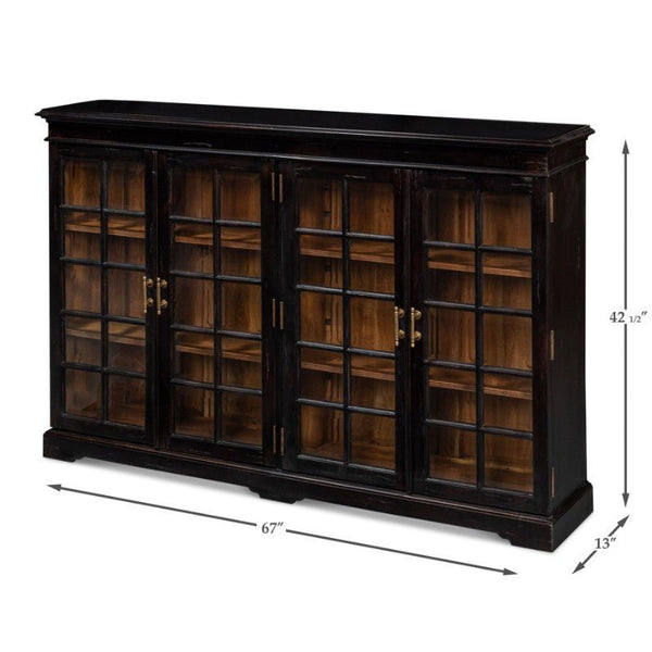 The Morgan Library Bookcase by Sarreid is a spacious black wooden cabinet featuring four glass-paneled doors that reveal solid walnut shelves inside. Measuring 67 inches in length, 42 inches in height, and 13 inches in depth, the cabinet is elegantly finished with antique brass accents on its gold handles.