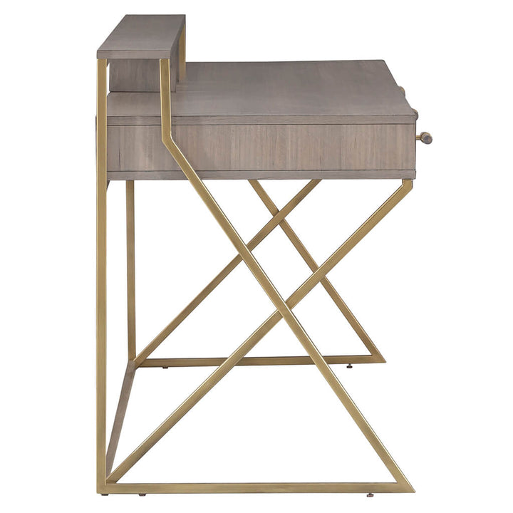 Side view of the Park Avenue Desk by Fairfield Chair, showcasing a beige finish and a distinct geometric metal frame with a gold-tone finish. Made from eucalyptus wood, this modern desk includes a top shelf and one drawer, bringing elegance to your contemporary home office.