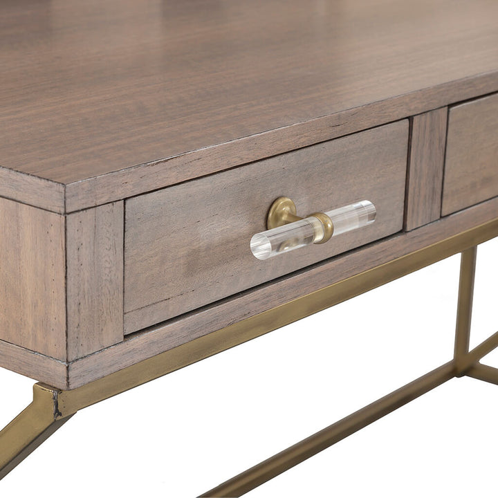 Close-up view of a wooden desk drawer with a glass and metal handle. The drawer is part of the Park Avenue Desk by Fairfield Chair, featuring a golden metal frame supporting the eucalyptus wood top. The wood has a smooth, finished texture, highlighting the grain. The background is white, perfect for a home office setting.