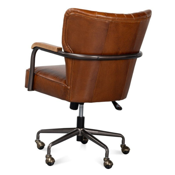 The Parker Office Chair in Vintage Havana Leather by Sarreid boasts a refined mid-century modern design with brown leather and wooden armrests. It features a high backrest, swivel base with five casters, and an adjustable height lever, all crafted from top-grain cow leather.