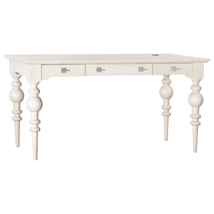 The Portofino Desk by Fairfield Chair is a white oak desk with three drawers and ornate, turned legs. It features square metal knobs on the drawers and a small cable management grommet on the back-left corner of the desktop, making it perfect for bringing coastal elegance to any room.