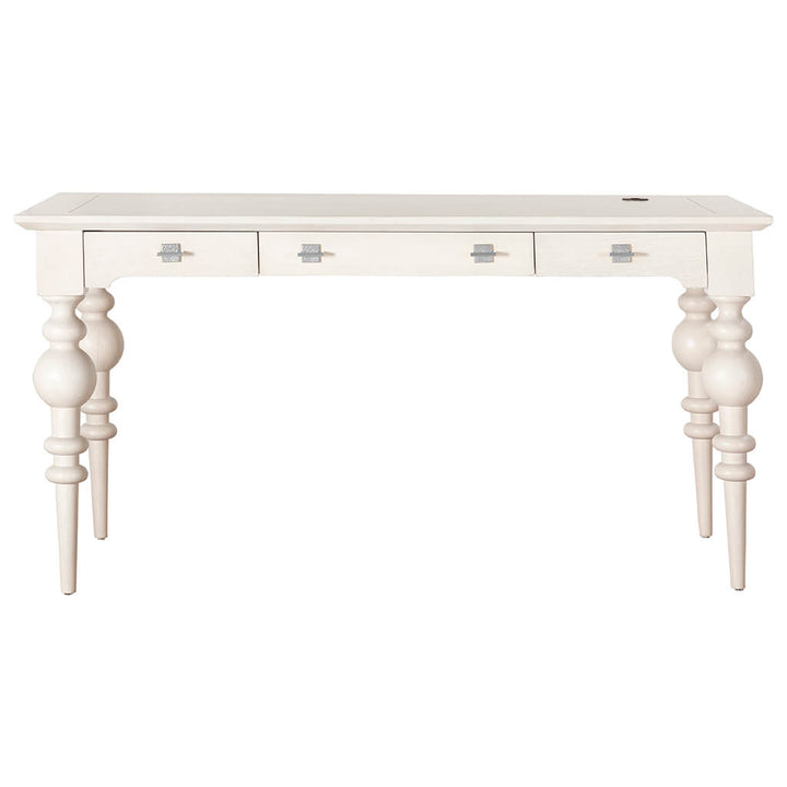 The Portofino Desk - Fairfield Chair by Fairfield Chair is a white desk with a smooth rectangular top, featuring three drawers with square silver handles. The desk stands on four intricately turned legs, giving it a classic, elegant look. The center drawer is slightly wider than the other two.