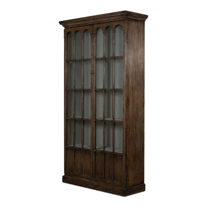 Introducing the Sarreid Refined Arches Tall Bookcase: a classic wooden display cabinet with traditional style, featuring tall, arching glass-paneled doors. Its rich, dark wood finish and elegant crown molding offer a vintage look. Inside, multiple shelves provide ample storage for collectibles or books.