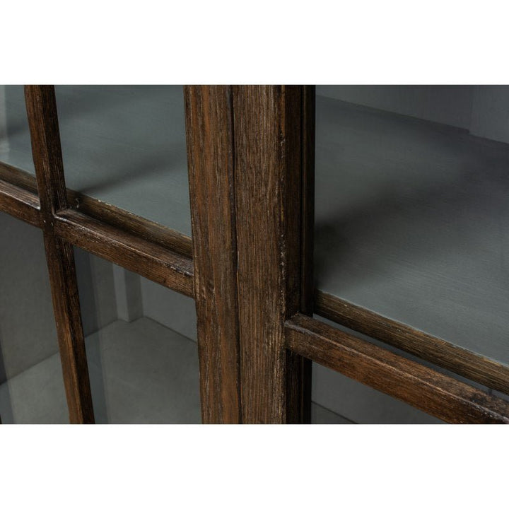 Close-up of the Refined Arches Tall Bookcase by Sarreid, showcasing its wooden frame with glass-paneled doors. The wood has a dark, rustic finish, and the clear glass reveals the interior shelves. This traditional style bookcase features a classic antique design with a weathered texture on the wood.