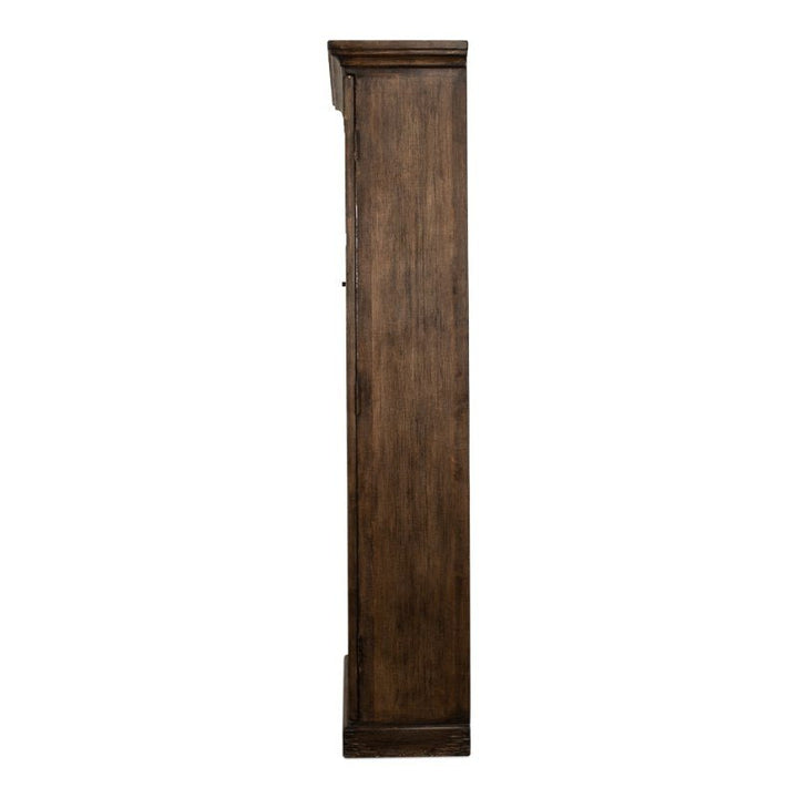 A side view of the Refined Arches Tall Bookcase by Sarreid, showcasing its tall and narrow wooden structure with a dark finish. The design features a plain, unadorned surface, embodying the simple elegance reminiscent of a traditional grandfather clock.