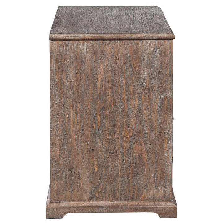 Side view of the Fairfield Chair Rustique Lateral File Cabinet with its rustic finish. This cabinet showcases a flat top, panel door, and a slightly protruding base, offering a robust and vintage appearance. The visible wood grain enhances its textured look while delivering modern functionality.