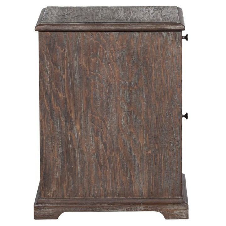 A wooden side table with rustic elegance, perfect for complementing the Fairfield Chair Rustique Writing Desk and Mobile File setup. The rectangular top is supported by a sturdy base featuring slightly curved details at the bottom. The side is adorned with a small metal handle for a drawer or cabinet door, adding to its charm.