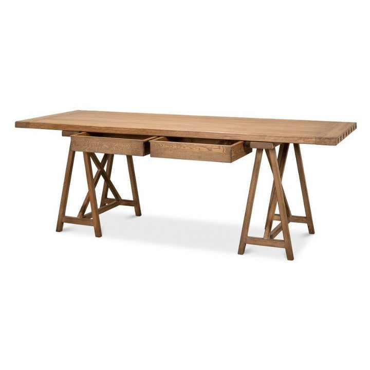 The Sawhorse Desk by Sarreid, crafted from natural polished old pine and measuring 87 inches, exudes rustic charm with its simplistic yet sturdy design. This rectangular wooden table features two drawers underneath and is supported by trestle legs on each side.