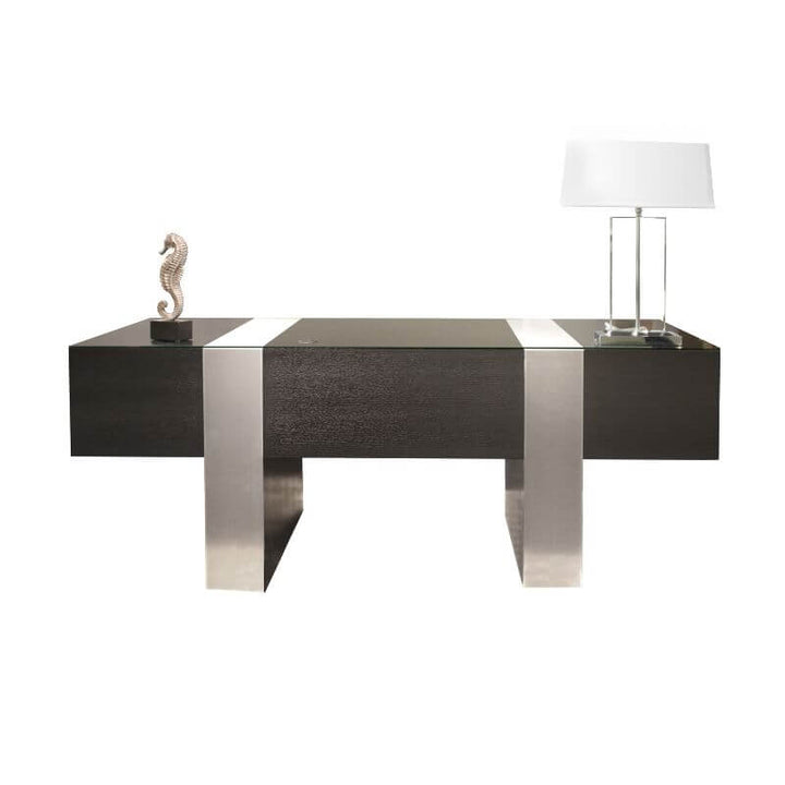 A modern home office setup with the sophisticated Sharelle Furnishings' Sharelle Nero Executive Desk - Wenge, boasting a sleek wenge finish and silver metallic legs. The desk features a decorative seahorse sculpture and a lamp with a white shade on its surface.