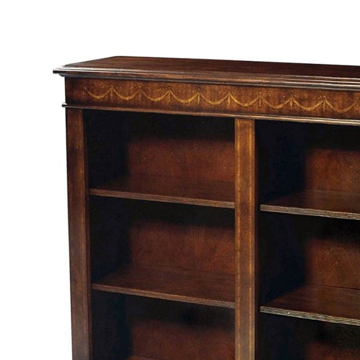 The Aston Court Small Mahogany Bookcase showcases elegant craftsmanship with a dark finish and an ornately carved top edge. Its compact design features two columns of three shelves each, highlighting the natural wood grain on the back and inner sides. Additionally, the top surface extends slightly beyond the sides.