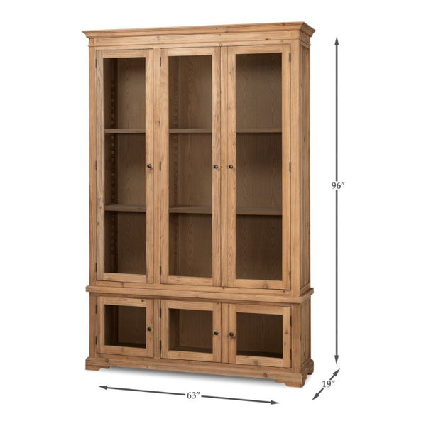 The Tanner Bookcase, Natural by Sarreid showcases a spacious wooden design featuring three glass-paneled upper doors and three solid lower doors. Standing 96 inches tall, 63 inches wide, and 19 inches deep, it is finished in a light natural brushed look that accentuates the beauty of reclaimed pine.