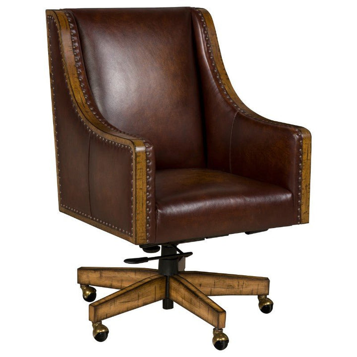 The Shard Office Swivel Chair by Fairfield Chair is an elegant office chair featuring a high backrest upholstered in brown aniline leather, detailed with nailhead trim along the edges. It includes wooden armrests and a wooden star-shaped base with rolling casters for mobility.