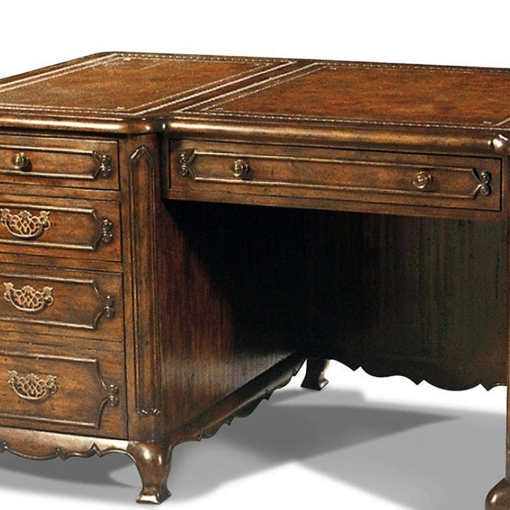 The Wesley Writing Desk from Aston Court is a handcrafted masterpiece featuring intricate carvings and metallic drawer handles. This elegant, vintage piece boasts multiple drawers on the left side, curved decorative legs, and an antique brown leather top that complements its rich, glossy finish.