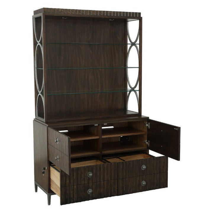 The West Camden Deck by Fairfield Chair showcases a dark wooden hutch with open shelving on top, accented by decorative metal side panels. Finished in an opulent Tahitian Pearl, the lower section includes two spacious drawers and two cabinets with doors slightly open to reveal extra storage space. The middle section features smaller open compartments and adjustable glass shelves.